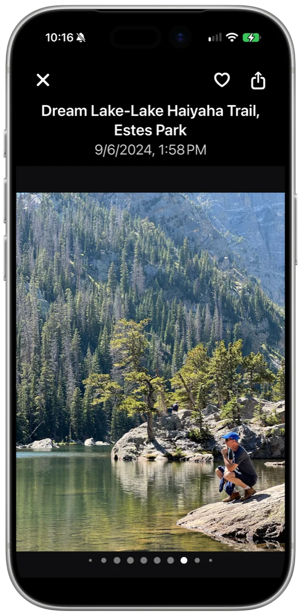 The full-screen viewer showing a lakeside photo with its place and date, and favorite and share buttons